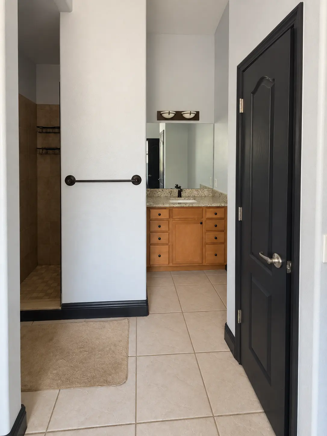 Bathroom hallway with tile floor and oak vanity before remodeling